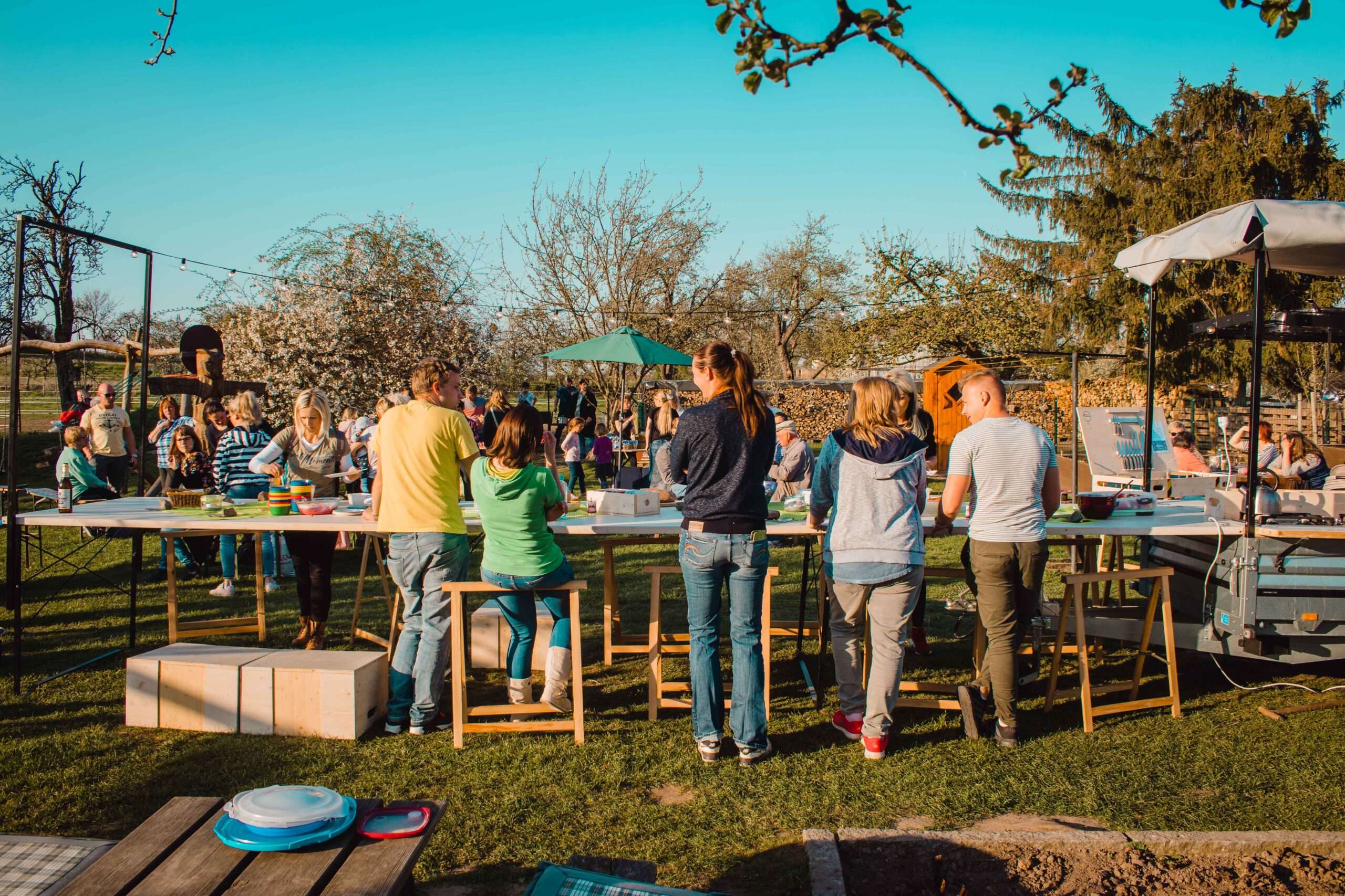 Familien am basteln an der langen Tafel an einem Sonnigen Tag im freien