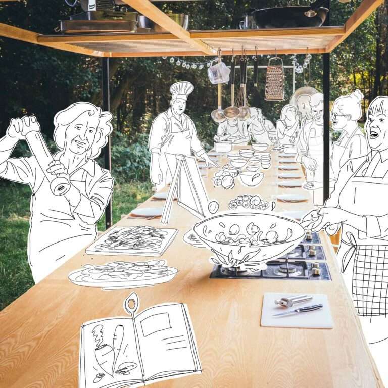 Menschen kochen an einer langen Tafel mit einem professionellen Koch