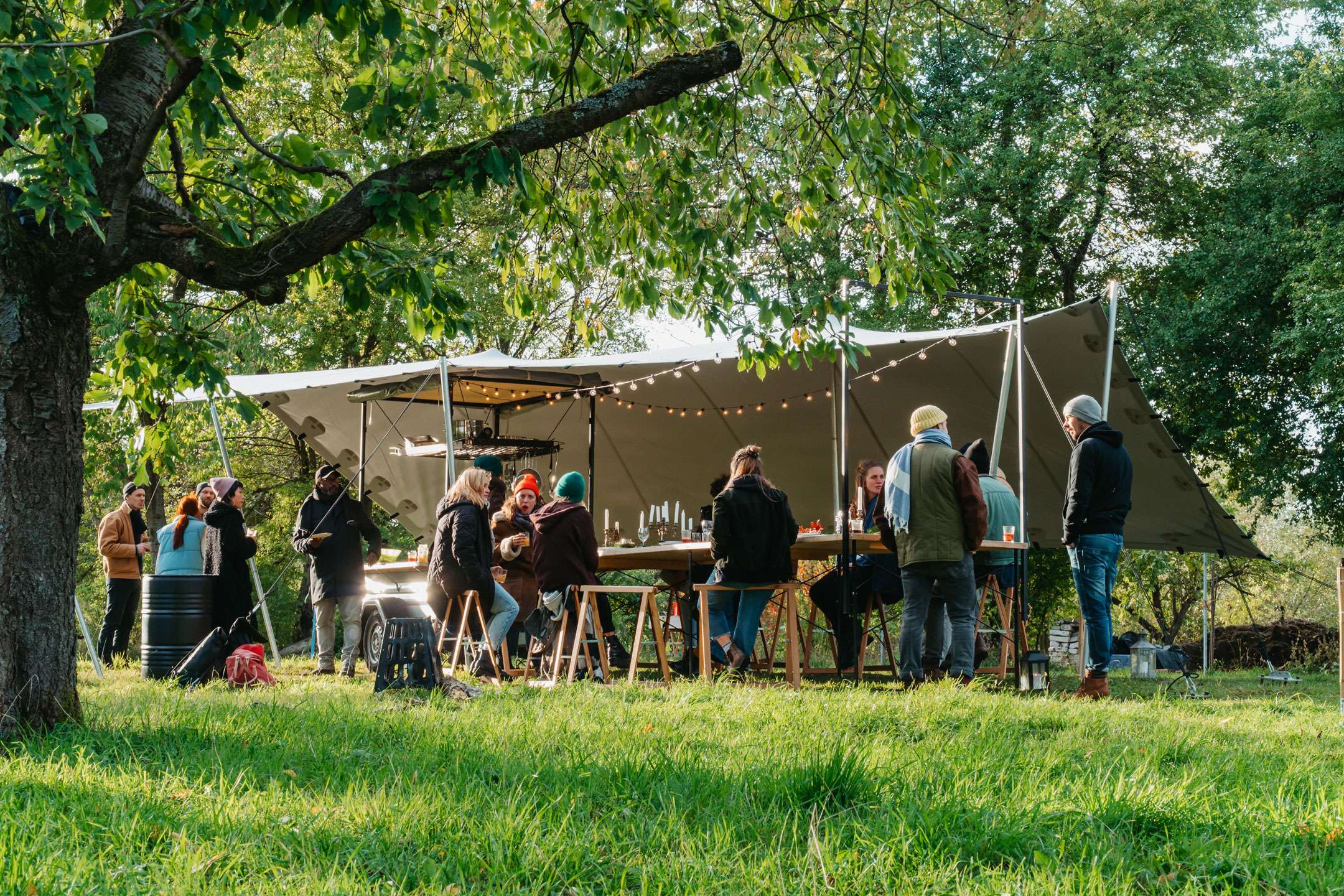 Überdachte lange Tafel mit einem Professionellen Zelt im unter Bäumen im Herbst